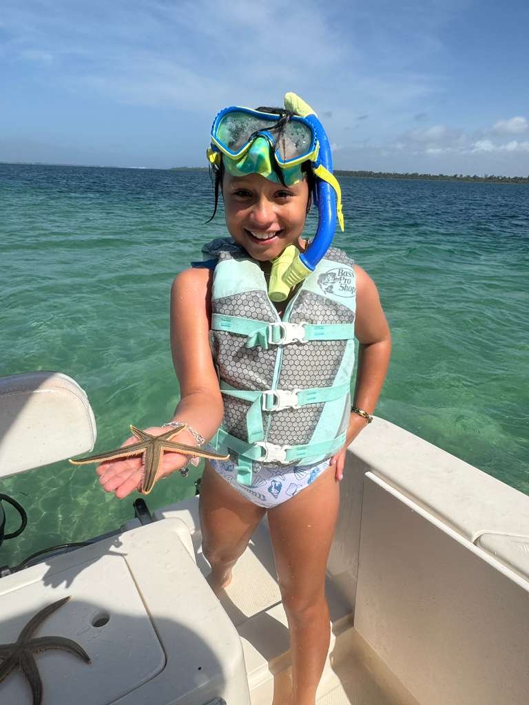 Guest holding starfish after snorkeling Shell Island